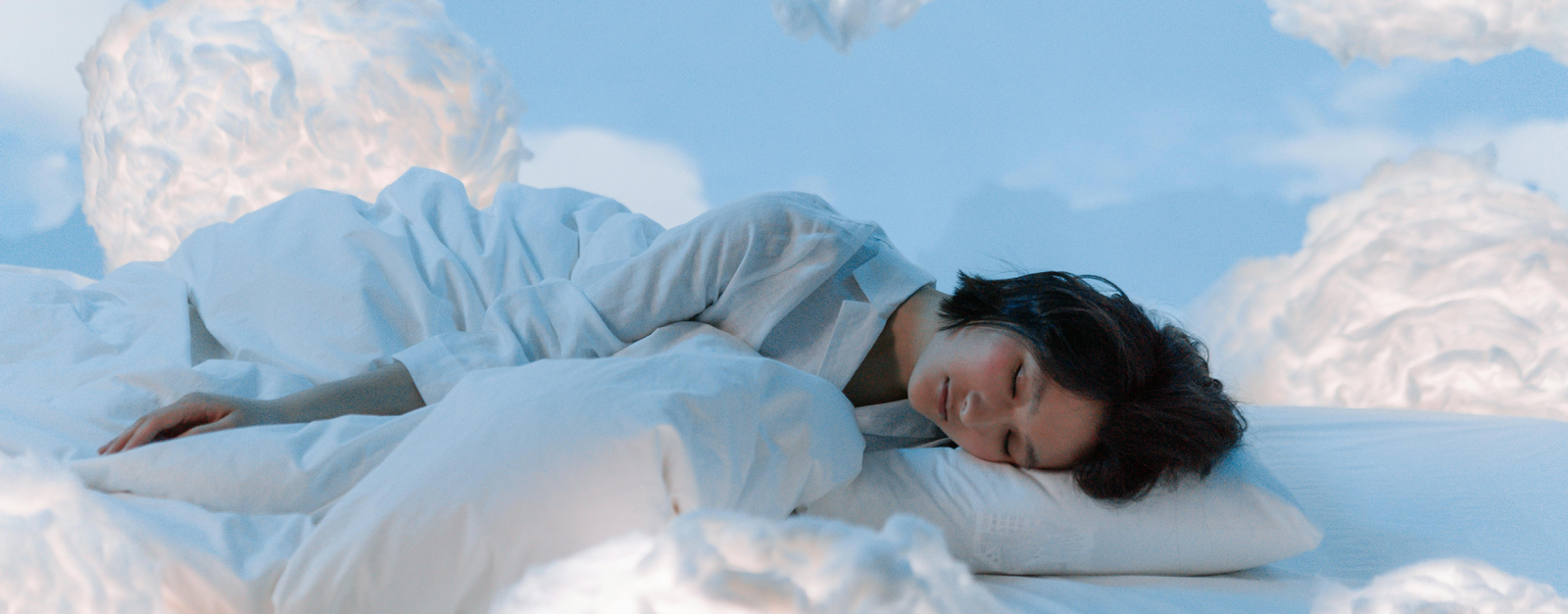 woman asleep surrounded by fluffy clouds