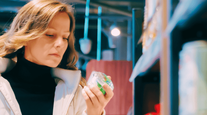 woman looking at a product label in the supermarket