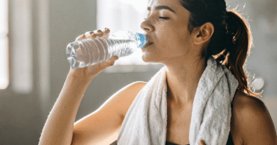 woman drinking water with towel around neck