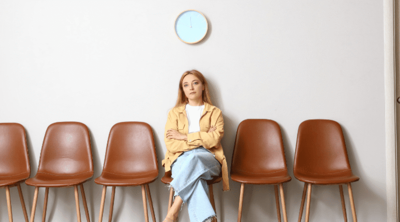 woman sitting alone in waiting room with brown chairs