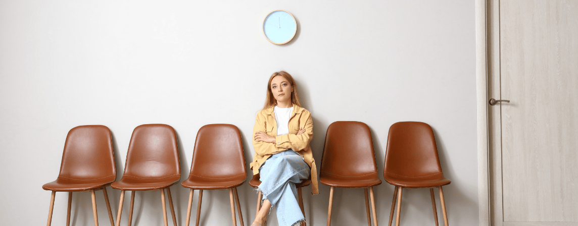 woman sitting alone in waiting room with brown chairs