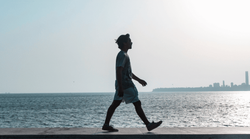 man walking on a beach path