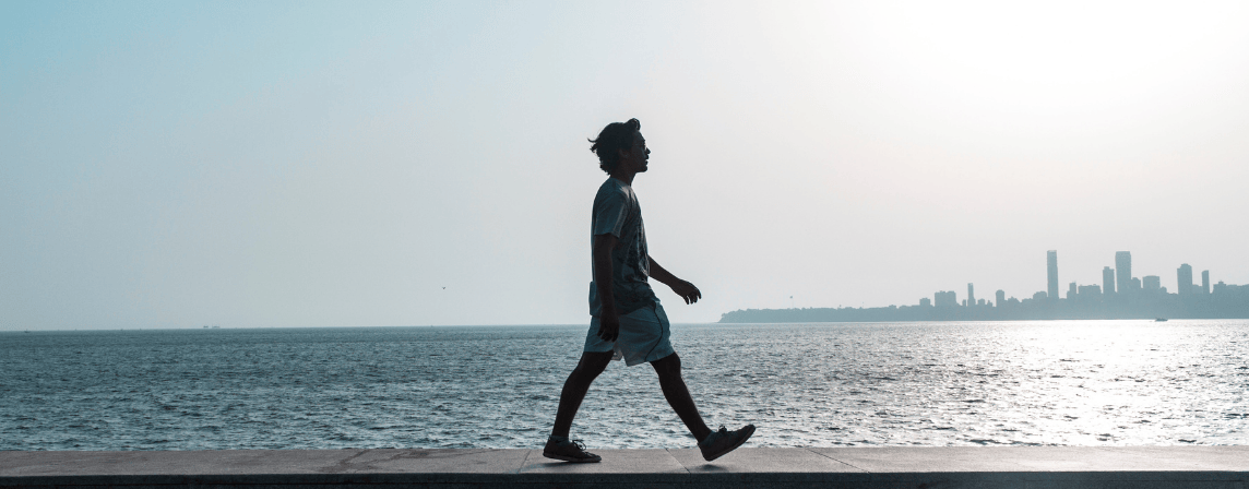 man walking on a beach path