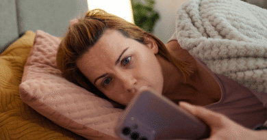 woman in bed looking at phone