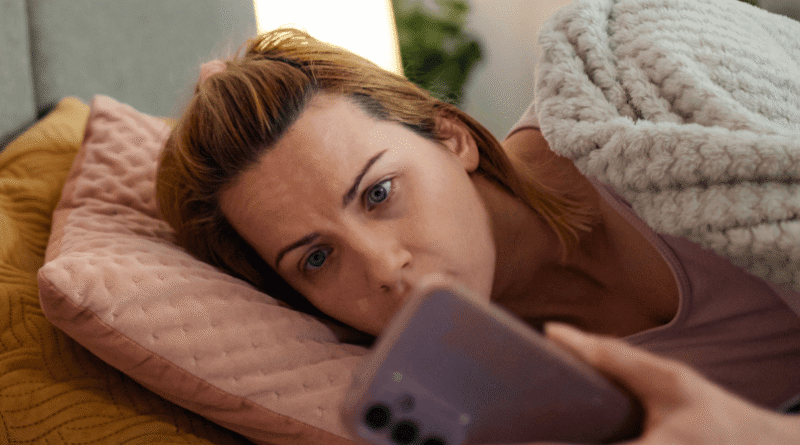 woman in bed looking at phone
