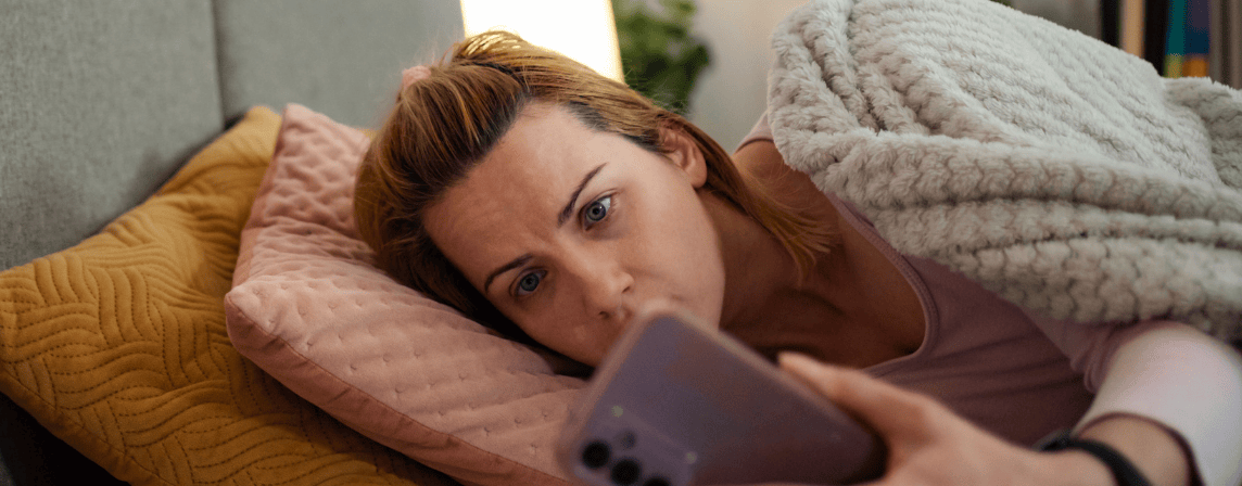 woman in bed looking at phone